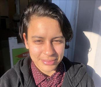 female employee with brown, red polka dot shirt and black jacket