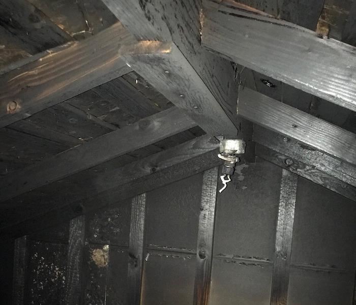 A room's framing is exposed and blackened from fire damage