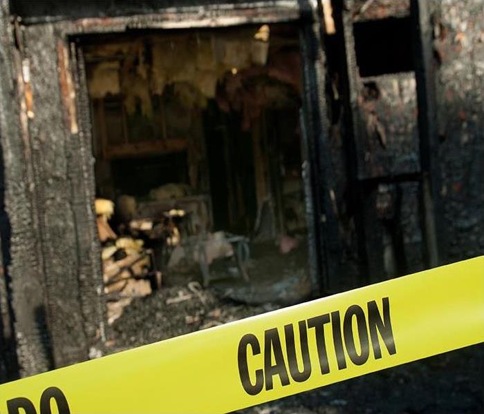 caution tape in front of fire damaged home