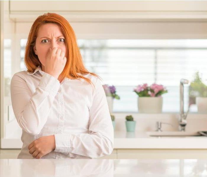 Woman holding her nose
